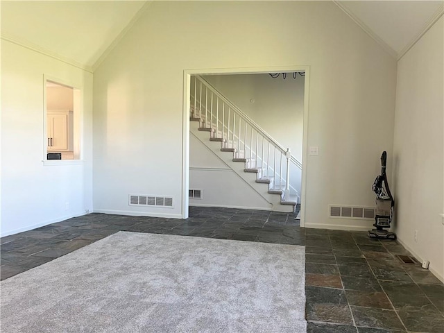 interior space featuring lofted ceiling and dark tile floors