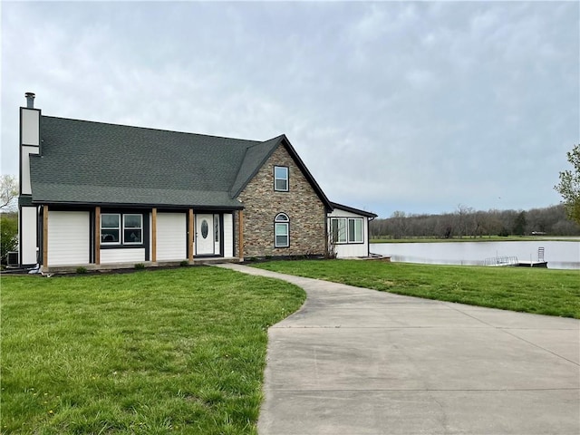 english style home with a water view and a front yard