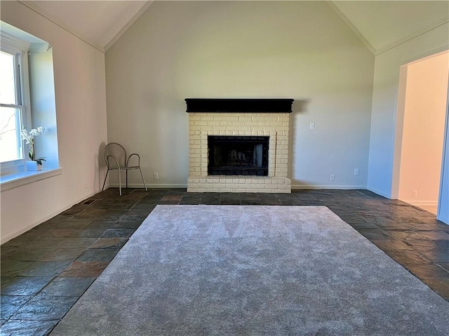 unfurnished living room with dark carpet, high vaulted ceiling, and a brick fireplace