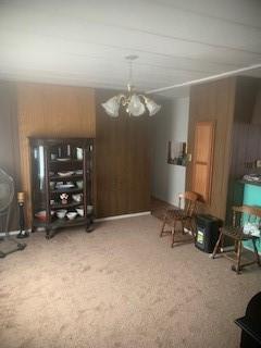 miscellaneous room with an inviting chandelier and carpet flooring