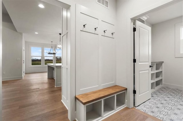 mudroom featuring a chandelier and light wood-type flooring