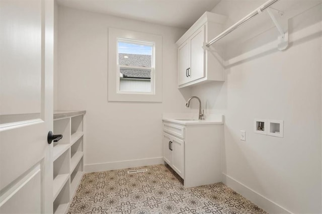 laundry area with sink, light tile flooring, cabinets, and washer hookup