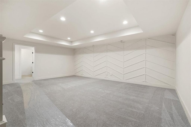 carpeted spare room with a tray ceiling