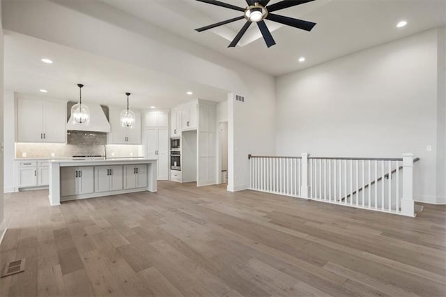 unfurnished living room with ceiling fan and light wood-type flooring