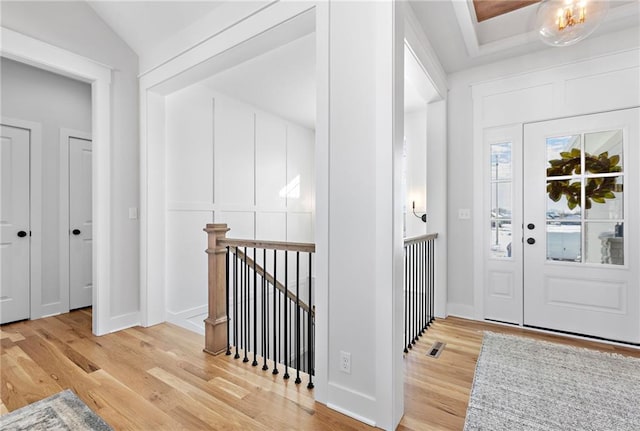 foyer entrance with light hardwood / wood-style flooring and lofted ceiling