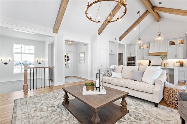 20132 Barker St, Spring Hill, KS 66083 - living room featuring light wood-style floors, beam ceiling, a chandelier, and high vaulted ceiling