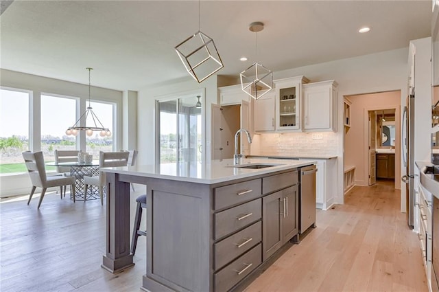 kitchen featuring white cabinets, backsplash, light hardwood / wood-style flooring, and hanging light fixtures