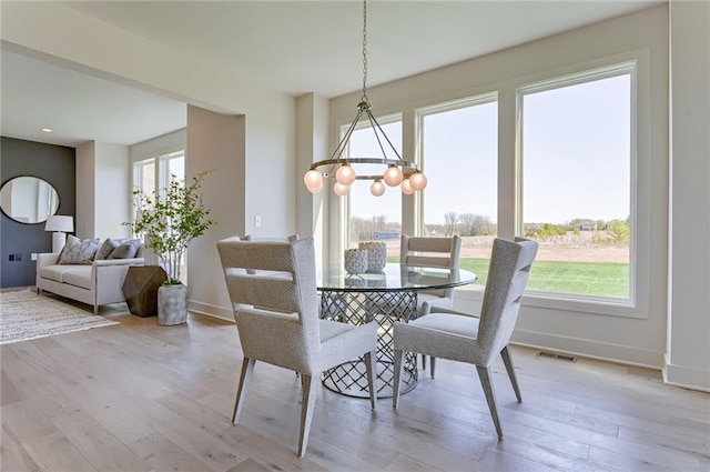 dining room with a notable chandelier and light wood-type flooring