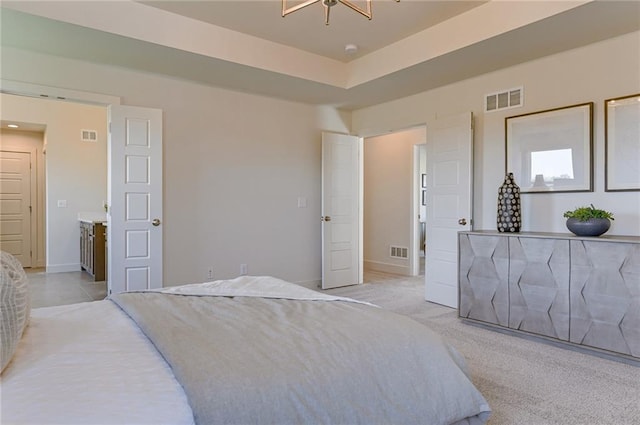 bedroom with light colored carpet and a raised ceiling