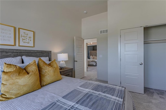 carpeted bedroom with a towering ceiling and a closet