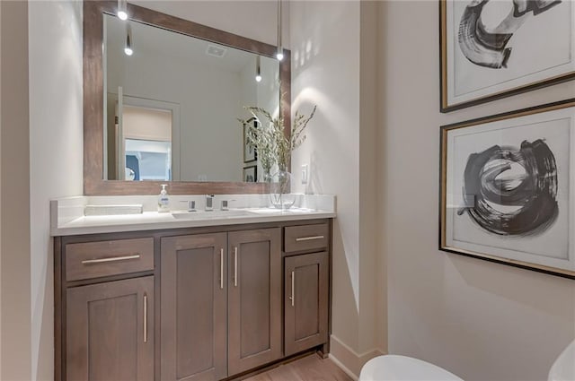 bathroom with hardwood / wood-style flooring, toilet, and vanity