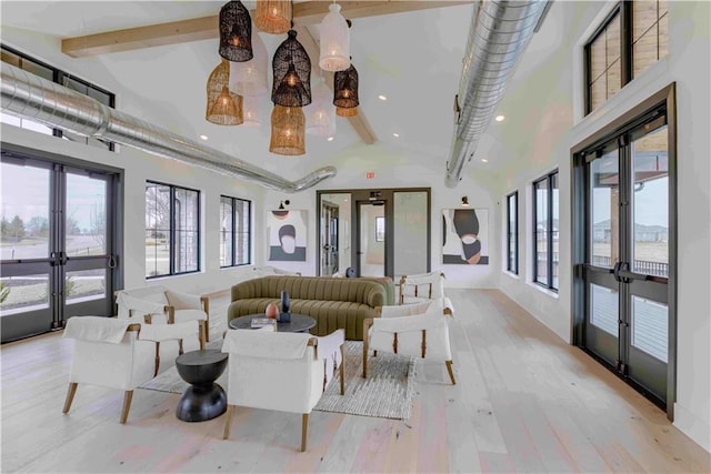 interior space with beamed ceiling, a healthy amount of sunlight, french doors, and light wood-type flooring