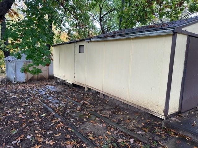 view of side of home featuring a shed