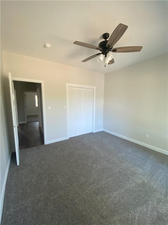 unfurnished bedroom with a closet, ceiling fan, and dark colored carpet