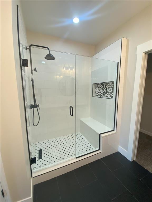 bathroom with a shower with door and tile patterned floors