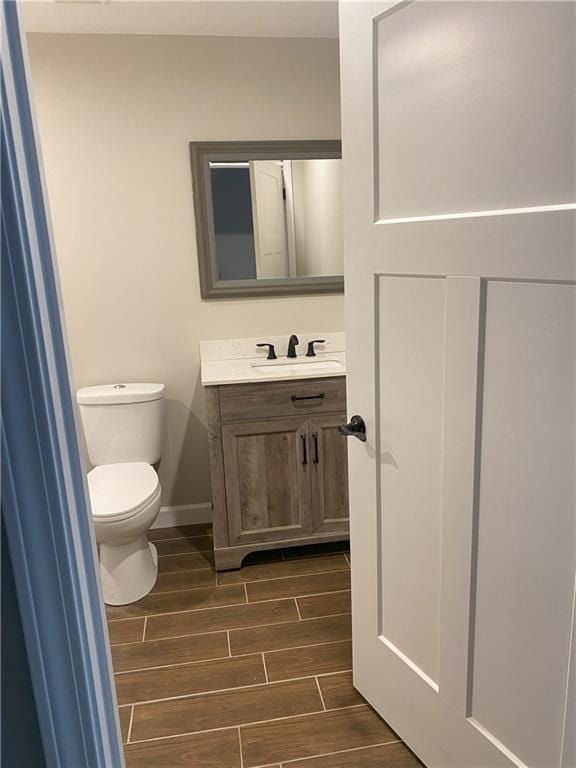 bathroom featuring vanity, hardwood / wood-style floors, and toilet