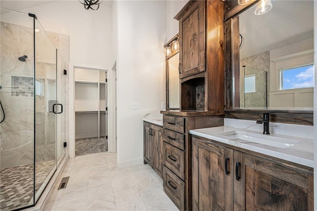 full bathroom featuring marble finish floor, baseboards, a shower stall, and vanity