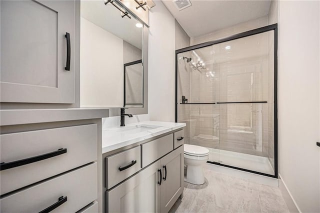 full bathroom featuring visible vents, a stall shower, vanity, and toilet