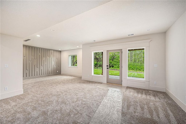 empty room featuring carpet floors, baseboards, and visible vents