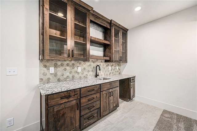 bar featuring tasteful backsplash, recessed lighting, a sink, and baseboards