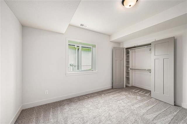 unfurnished bedroom featuring carpet floors, a closet, visible vents, and baseboards