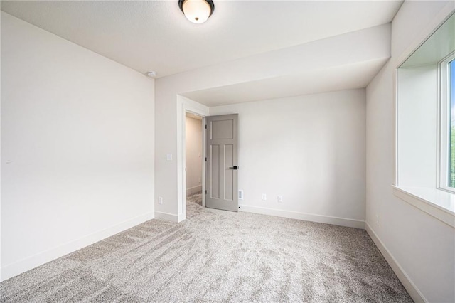 carpeted empty room with baseboards