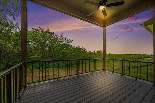 deck at dusk featuring ceiling fan