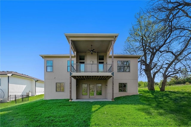 back of house featuring fence, a ceiling fan, and a yard