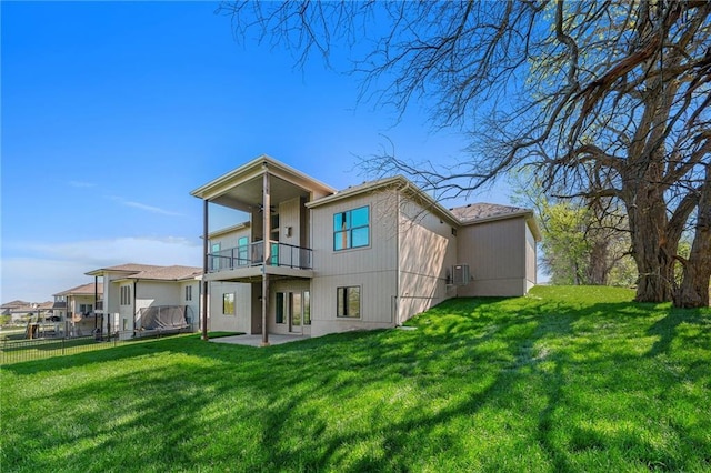 back of house with a yard, a patio area, fence, and a balcony