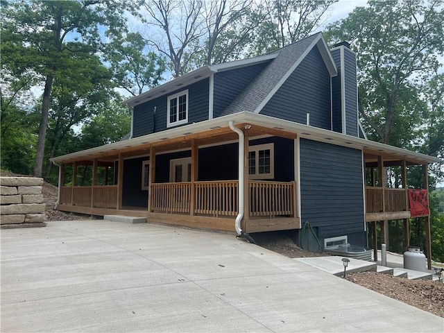 7930 Eagle Bay Dr, Gravois Mills, MO 65037 - farmhouse inspired home featuring roof with shingles, a porch, and a chimney