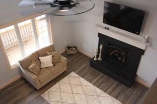 living room featuring ceiling fan, a wealth of natural light, and wood-type flooring