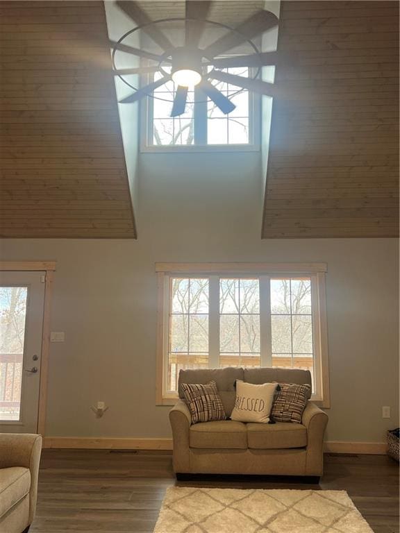 living room with a towering ceiling, a healthy amount of sunlight, and hardwood / wood-style floors