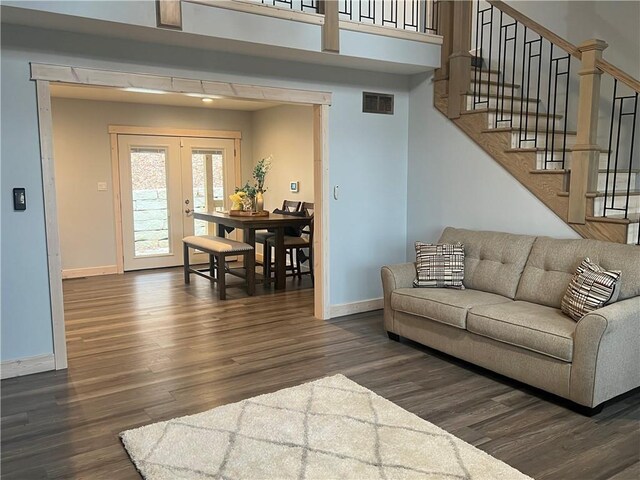 living room with french doors and dark wood-type flooring