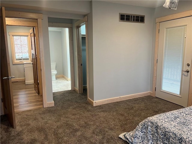 bedroom with dark colored carpet and connected bathroom