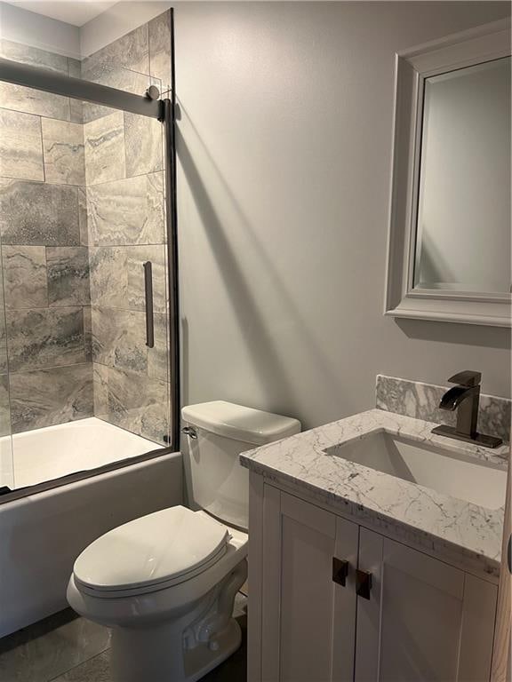 full bathroom with combined bath / shower with glass door, vanity, toilet, and tile floors