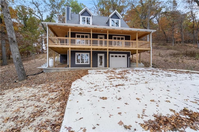7930 Eagle Bay Dr, Gravois Mills, MO 65037 - view of front of house featuring an attached garage, a deck, driveway, and a chimney