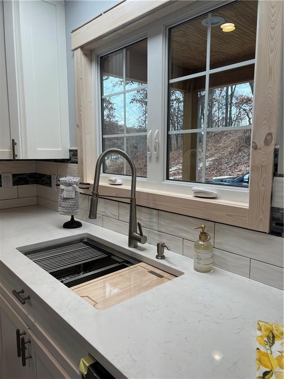7930 Eagle Bay Dr, Gravois Mills, MO 65037 - kitchen with a healthy amount of sunlight, a sink, and backsplash
