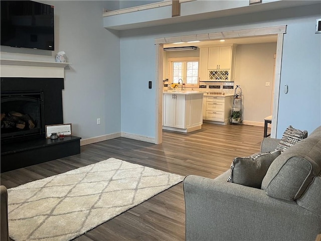 7930 Eagle Bay Dr, Gravois Mills, MO 65037 - living room with dark wood-type flooring, visible vents, baseboards, and a fireplace with raised hearth