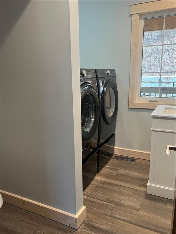 7930 Eagle Bay Dr, Gravois Mills, MO 65037 - clothes washing area with washer and dryer, laundry area, wood finished floors, and baseboards