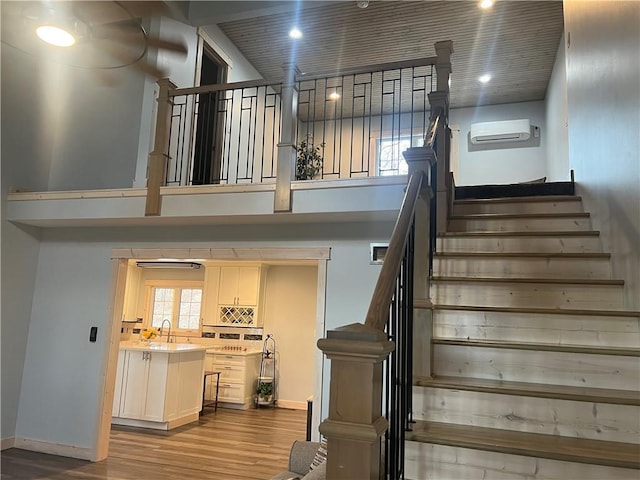7930 Eagle Bay Dr, Gravois Mills, MO 65037 - stairway with recessed lighting, a wall mounted AC, wood finished floors, a high ceiling, and baseboards