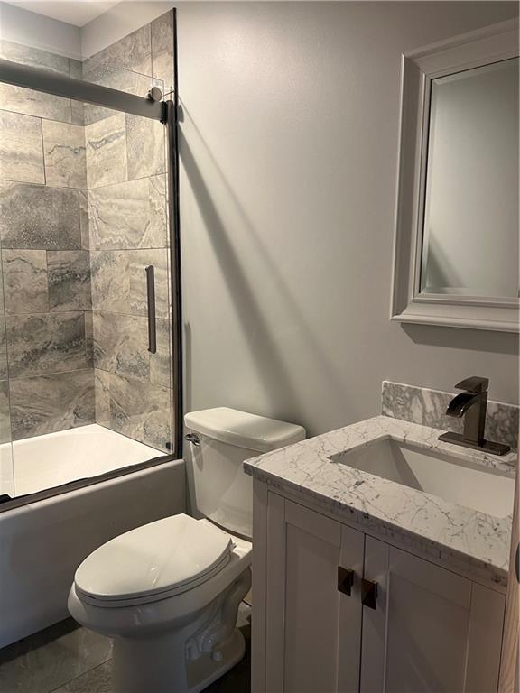 7930 Eagle Bay Dr, Gravois Mills, MO 65037 - bathroom featuring toilet, vanity, and enclosed tub / shower combo