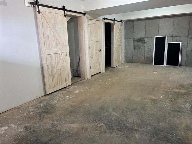 7930 Eagle Bay Dr, Gravois Mills, MO 65037 - interior space featuring unfinished concrete floors, a barn door, and multiple closets
