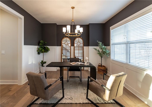 office featuring a wainscoted wall, an inviting chandelier, wood finished floors, and a decorative wall