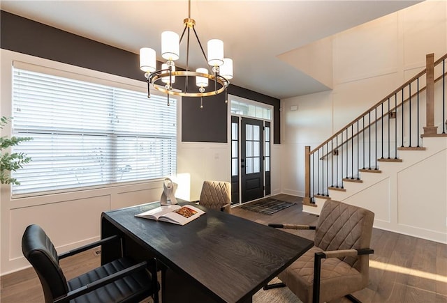 office space with wood finished floors, an inviting chandelier, and a decorative wall