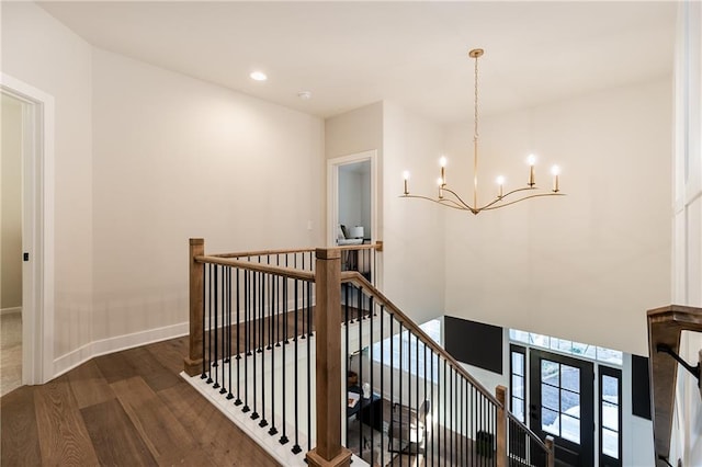 stairway featuring a notable chandelier and hardwood / wood-style floors