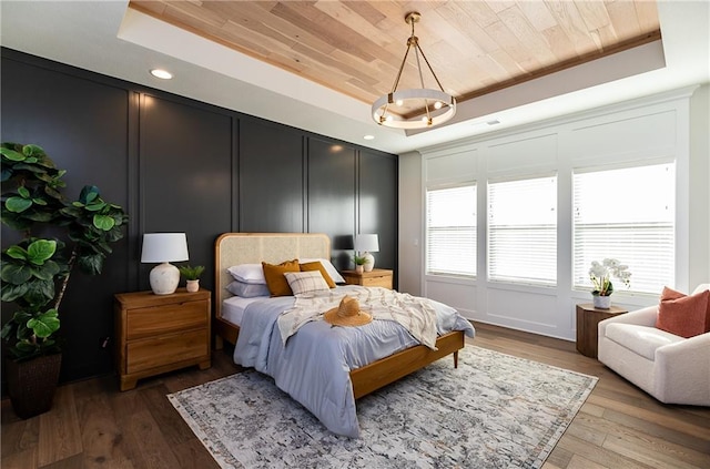 bedroom with wooden ceiling, a raised ceiling, hardwood / wood-style flooring, and recessed lighting