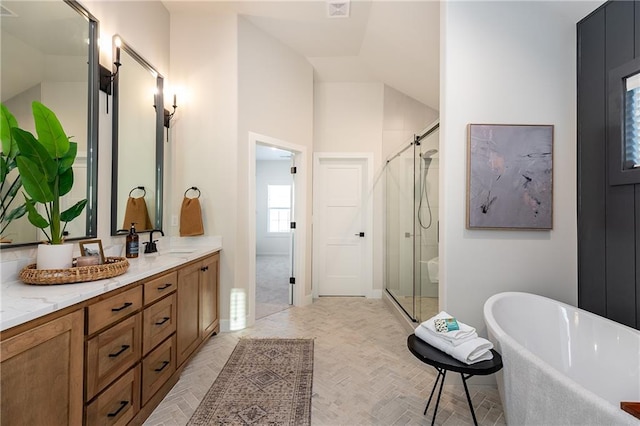 bathroom featuring vanity, vaulted ceiling, and independent shower and bath