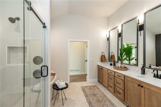 bathroom featuring double vanity, visible vents, a shower stall, and a sink
