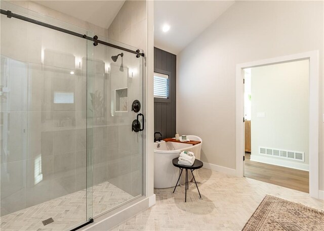 bathroom with hardwood / wood-style floors, shower with separate bathtub, and vaulted ceiling