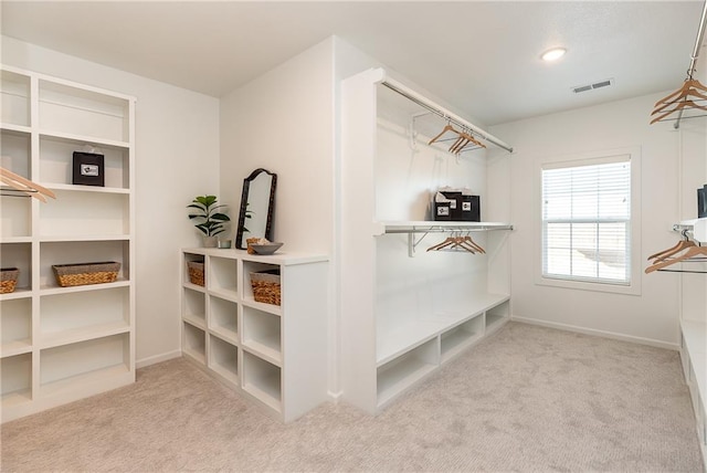 walk in closet featuring light colored carpet